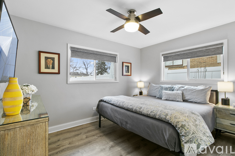 A bedroom with a bed, dresser, and ceiling fan.