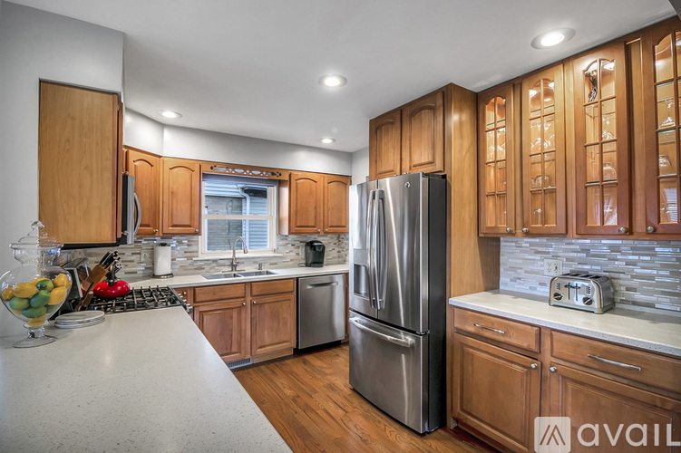 A kitchen with wooden cabinets and a stainless steel refrigerator.