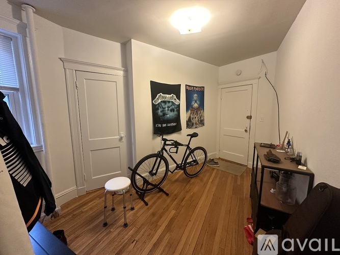 A room with a bicycle and a poster on the wall.