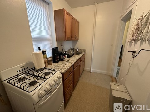 A kitchen with a white gas stove and wooden cabinets.