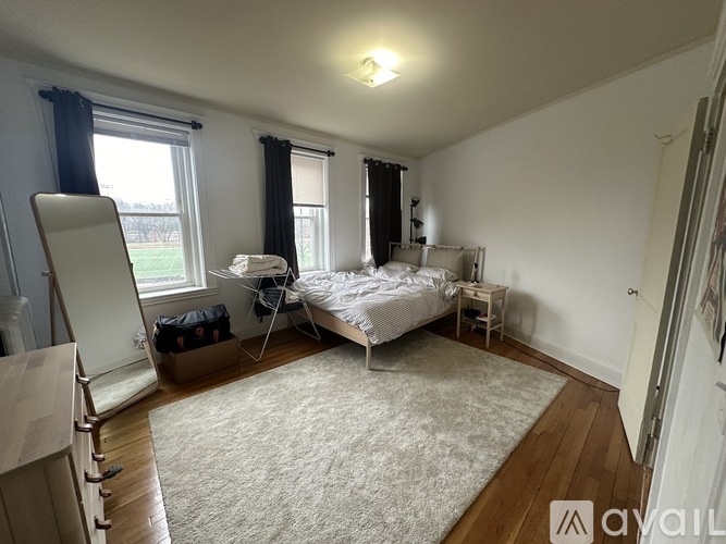 A bedroom with a bed, nightstand, and window.