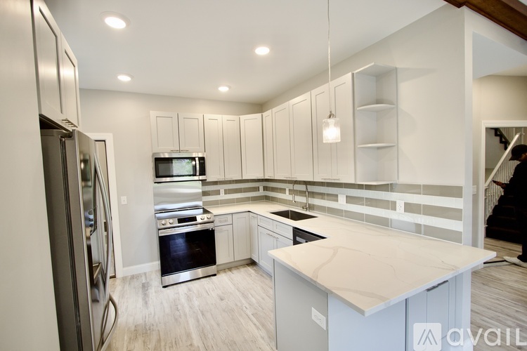 A kitchen with a refrigerator, oven, and microwave.