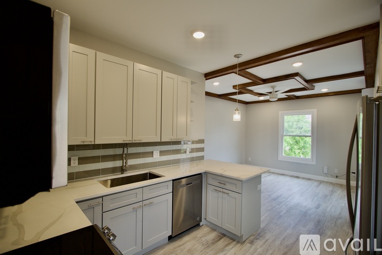 A kitchen with white cabinets and a window.