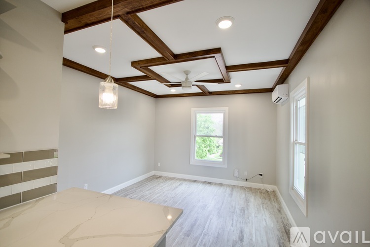 A room with wooden beams on the ceiling and a window.