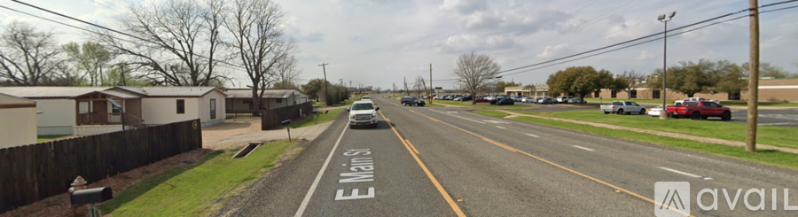 A street view of E Main St with cars parked on the side of the road.