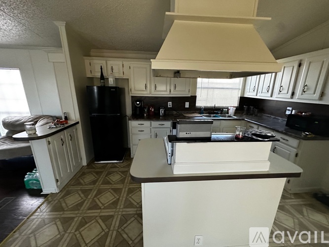 A kitchen with black appliances and white cabinets.
