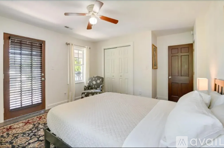 A bedroom with a large bed and a ceiling fan.