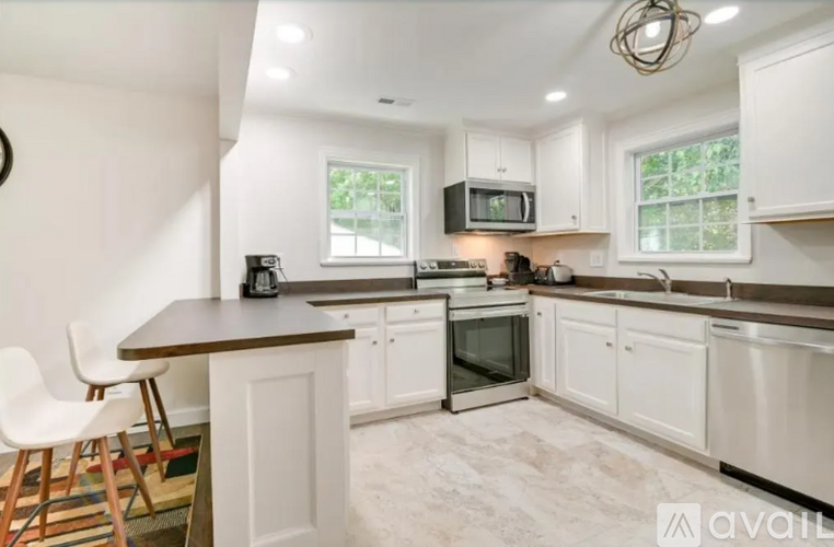 A kitchen with white cabinets and a wooden island.
