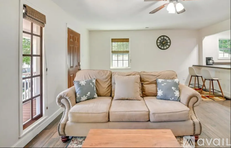 A living room with a beige couch and a wooden coffee table.