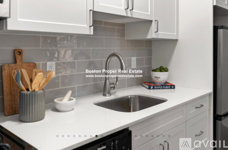 A kitchen with a sink and a book titled "Boston Apart".