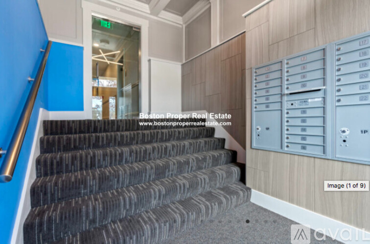 A staircase with a blue wall on the left and a white wall on the right with mailboxes.