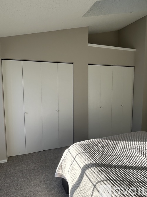 A bedroom with a bed and two wardrobes.