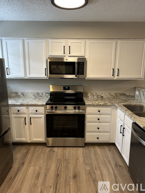 A kitchen with white cabinets and a black stove top oven.