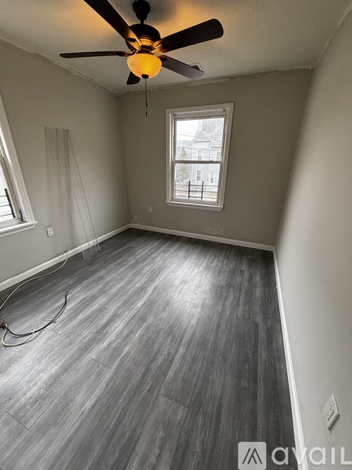 A room with a ceiling fan and a window.