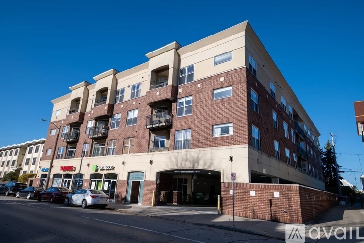 A multi-story building with a parking lot in front.