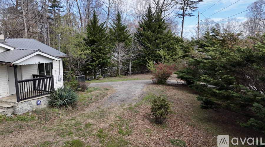 A house with a yard and trees in the background.