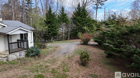 A house with a yard and trees in the background.