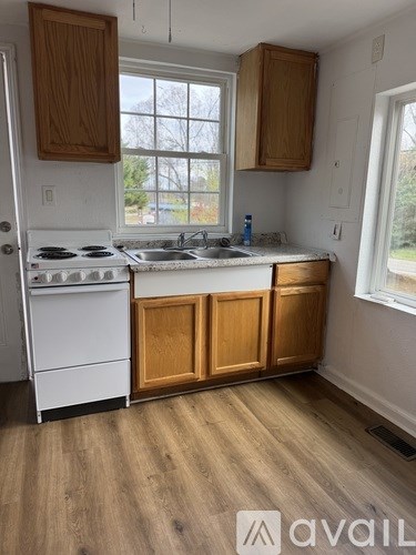 A kitchen with wooden cabinets and a white stove top oven.