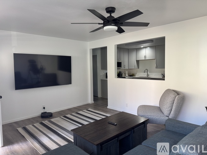 A living room with a television, a chair, and a coffee table.