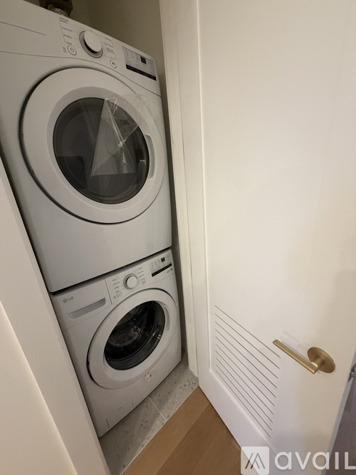 A white front loading washing machine in a small room.