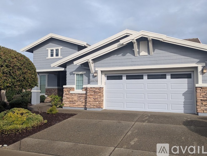 A house with a garage and a driveway in front.