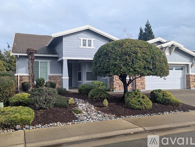 A house with a grey exterior and a landscaped front yard.
