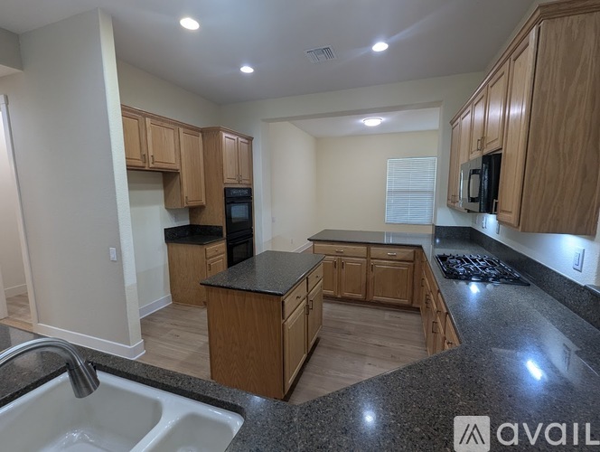 A kitchen with wooden cabinets and granite countertops.