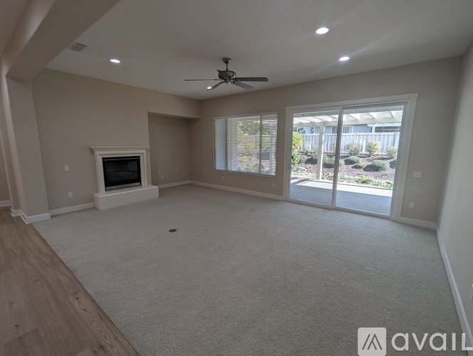 A spacious living room with a fireplace and sliding glass doors.