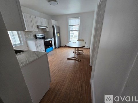 A kitchen with white cabinets and a blue fridge.
