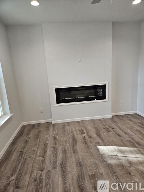 A room with a fireplace and wooden flooring.