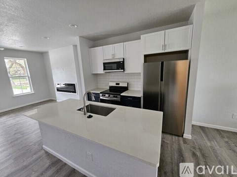 A kitchen with white cabinets and stainless steel appliances.