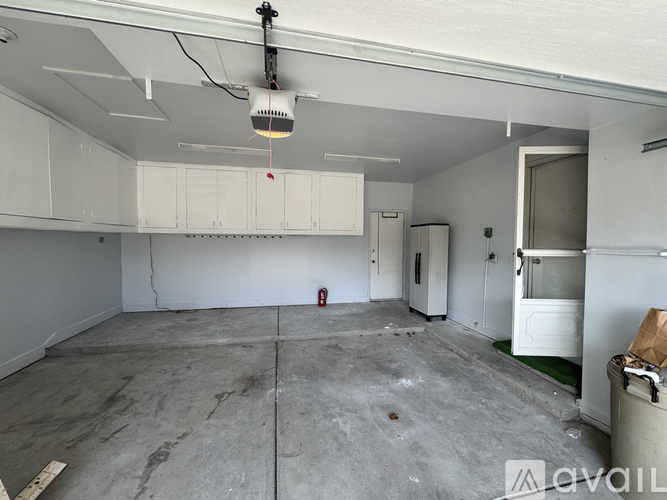 A large empty room with a white ceiling and a fire extinguisher on the wall.