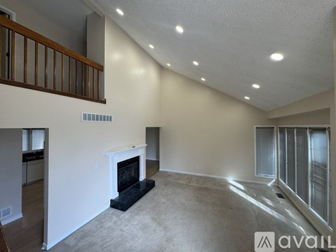 A living room with a fireplace and a carpet.