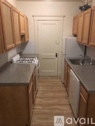 A kitchen with wooden cabinets and a white door.