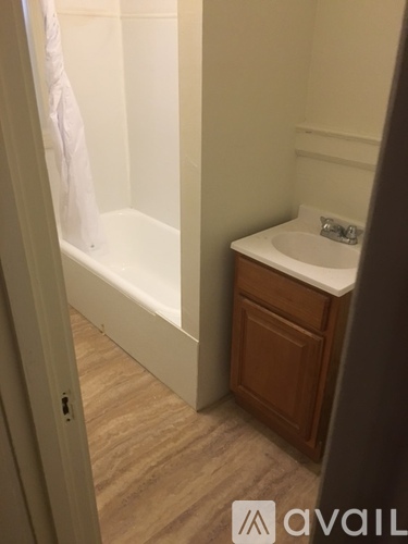 A white sink is on a wooden cabinet in a bathroom.