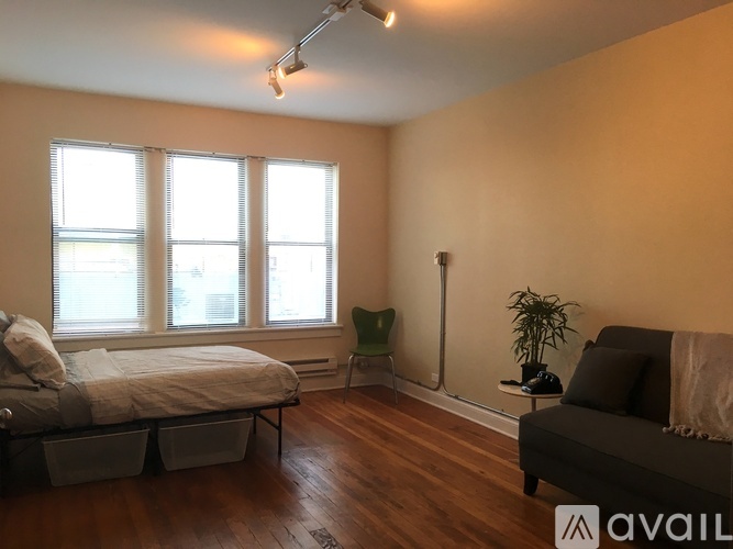 A bedroom with a bed, a chair, and a couch.