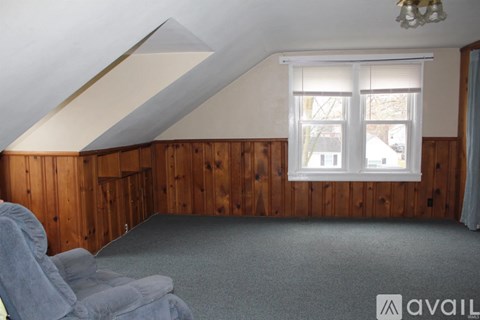 A room with wooden walls and a window with blinds.
