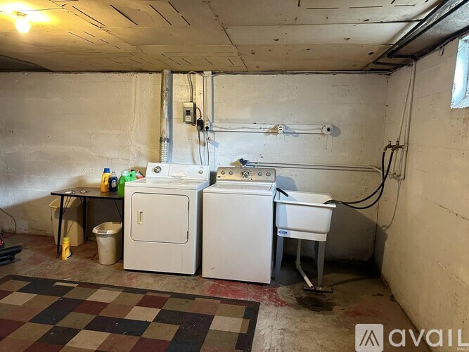 A dirty basement with a washer and dryer.
