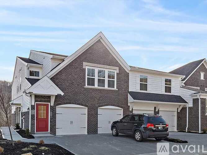 A house with a red door and a black car in front.