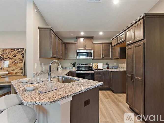 A kitchen with brown cabinets and a granite countertop.