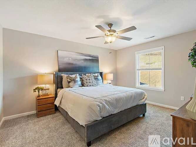 A bedroom with a large bed and a ceiling fan.