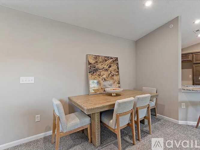 A dining room with a wooden table and chairs.