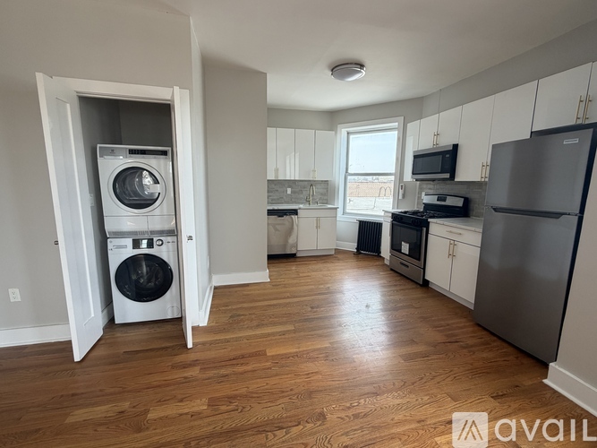 A kitchen with a washing machine in the doorway.