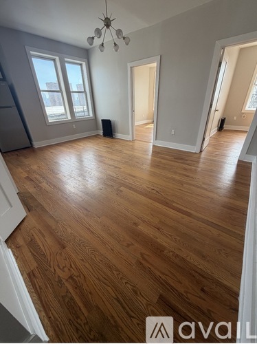 A room with wooden flooring and a chandelier.