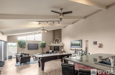A spacious living room with a pool table and a fireplace.