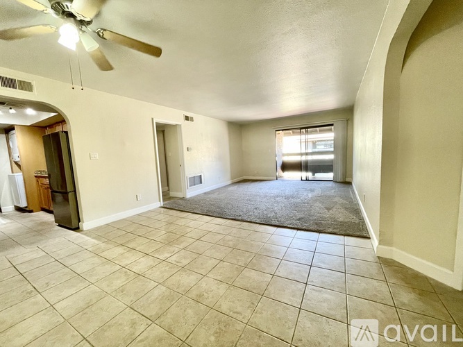 A spacious room with a ceiling fan and tiled floor.