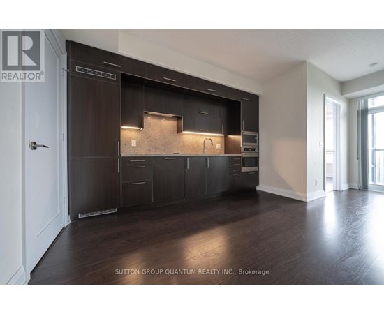 A modern kitchen with dark wood cabinets and a countertop.