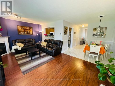 A living room with a black couch and a white table.