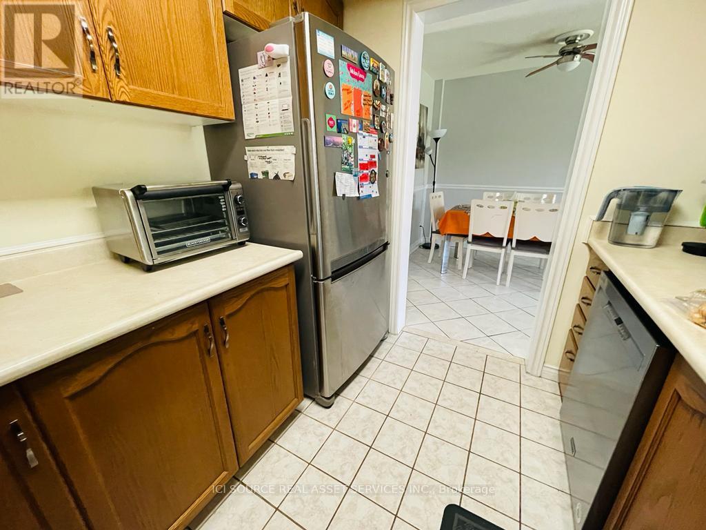 A kitchen with a refrigerator covered in magnets and a toaster oven on the counter.