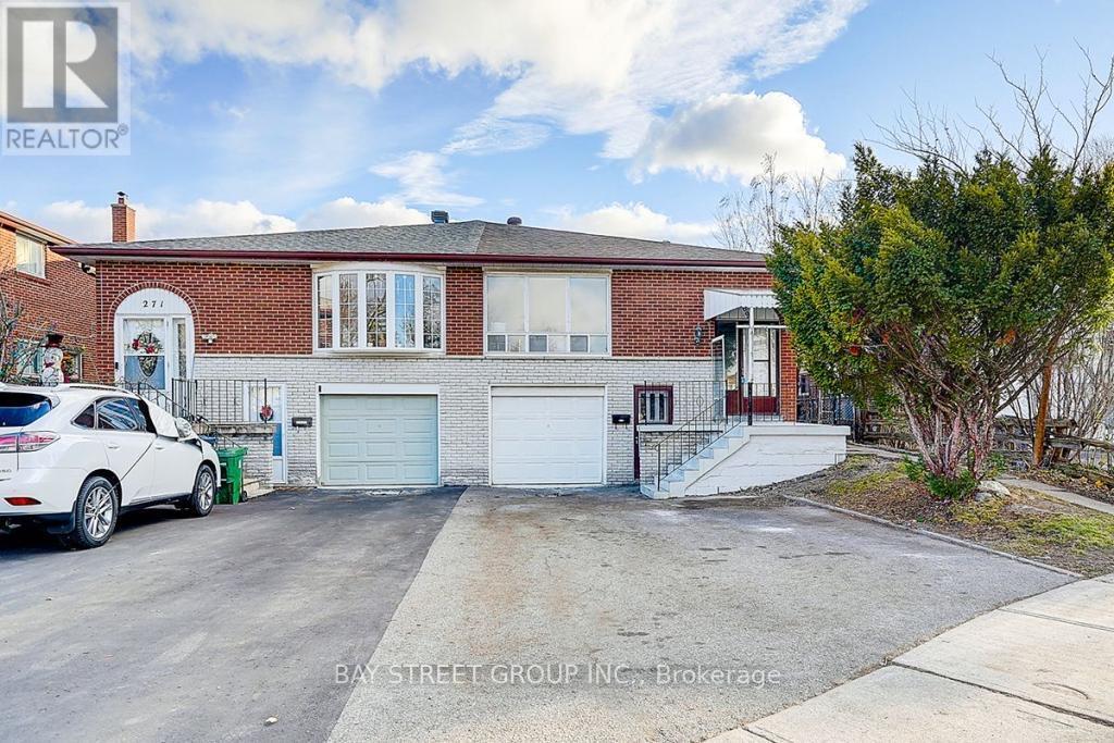 A white car is parked in front of a brick house.